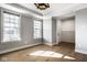 Bright living room featuring hardwood floors, two large windows, and a modern light fixture at 2779 Ruffian Dr, Westfield, IN 46074