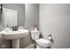 Charming powder room with a pedestal sink, white toilet, and decorative accents at 2779 Ruffian Dr, Westfield, IN 46074