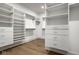 Spacious walk-in closet with custom shelving, drawers, and hardwood floors at 2779 Ruffian Dr, Westfield, IN 46074