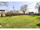Large backyard featuring green grass, a shed, surrounded by a wooden fence and mature trees at 3607 Windsor Way, Anderson, IN 46011