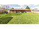 Spacious backyard with a well-maintained lawn, leading to a brick home exterior with lush greenery at 3607 Windsor Way, Anderson, IN 46011
