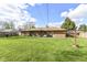 Expansive backyard with a well-kept lawn, leading to a brick home exterior and mature trees at 3607 Windsor Way, Anderson, IN 46011