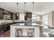 Open concept kitchen with dark cabinetry, granite countertops, and breakfast bar at 3728 Dunellen Cir, Carmel, IN 46074