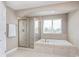 Bright bathroom with a soaking tub, glass enclosed shower, and neutral tile at 3728 Dunellen Cir, Carmel, IN 46074