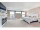 Spacious main bedroom with a fireplace, three windows, and a tufted headboard at 3728 Dunellen Cir, Carmel, IN 46074