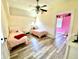 Bedroom with two beds, ceiling fan, and adjoining room painted in a bright pink color at 4029 W Fairview Rd, Greenwood, IN 46142