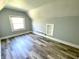 A bright, finished attic bedroom featuring wood-look flooring, a closet nook, and built in shelves at 4029 W Fairview Rd, Greenwood, IN 46142