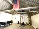View of garage displaying storage, patriotic decor, and lawn equipment at 4029 W Fairview Rd, Greenwood, IN 46142