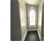 A narrow hallway featuring gray walls and dark hardwood floors highlighted by a gothic style window at 4029 W Fairview Rd, Greenwood, IN 46142