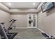 Basement exercise area with elliptical, exercise bike and view into an adjacent room at 4312 S Woodbridge Ln, New Palestine, IN 46163