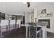 An open dining area features a cozy fireplace, bar seating, and a view into the kitchen at 4312 S Woodbridge Ln, New Palestine, IN 46163