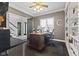 This home office features a wood desk, grey walls and dark floors for a comfortable and professional workspace at 4312 S Woodbridge Ln, New Palestine, IN 46163