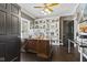 Cozy home office with built-in bookshelves, a large desk, and hardwood floors at 4312 S Woodbridge Ln, New Palestine, IN 46163