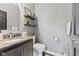 Well-lit powder room featuring dark vanity, granite countertop, and modern fixtures at 4312 S Woodbridge Ln, New Palestine, IN 46163
