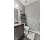 Well-lit powder room with dark vanity, granite countertop, and decorative shelving at 4312 S Woodbridge Ln, New Palestine, IN 46163