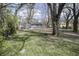 View of the grassy backyard with mature trees and a small shed in the distance at 4342 Lasalle St, Indianapolis, IN 46205