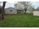 Backyard view featuring green grass, trees, and a storage shed at 4431 Bertrand Rd, Indianapolis, IN 46222