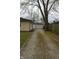 A shot down the gravel driveway towards the detached garage behind the house at 4431 Bertrand Rd, Indianapolis, IN 46222