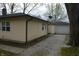Exterior of the house with a view of the detached garage down the gravel driveway at 4431 Bertrand Rd, Indianapolis, IN 46222
