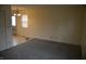 Open living room featuring carpet, a window with blinds, and an adjacent dining area at 4431 Bertrand Rd, Indianapolis, IN 46222