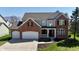 Beautiful two-story home featuring a brick facade, attached two-car garage, and well-manicured lawn at 5145 Greenheart Pl, Indianapolis, IN 46237