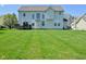Back exterior view of home featuring a spacious lawn and deck at 5145 Greenheart Pl, Indianapolis, IN 46237