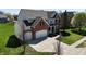 Charming two-story home with a brick facade, spacious driveway, and nicely landscaped yard at 5145 Greenheart Pl, Indianapolis, IN 46237