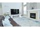 Bright living room with fireplace, TV, and a comfortable brown leather sofa with blue pillows at 5145 Greenheart Pl, Indianapolis, IN 46237