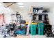Cluttered garage space with motorcycles, bicycles, storage shelving, and other miscellaneous items at 5301 Tanglewood Ln, Whitestown, IN 46075