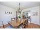 Open-concept dining room with a wooden table, chandelier, and view into the living room at 6018 Maple Forge Cir, Indianapolis, IN 46254