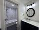 Bathroom with tub-shower, black fixtures, and marble patterned shower surround at 609 W Pearl St, Trafalgar, IN 46181