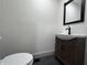 Charming powder room with a modern vanity, faucet, and a sleek black-framed mirror at 609 W Pearl St, Trafalgar, IN 46181