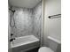 Bathroom with tub-shower, black fixtures, and marble patterned shower surround at 609 W Pearl St, Trafalgar, IN 46181