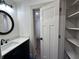 Bathroom with vanity, black fixtures, and doorway to walk-in closet at 609 W Pearl St, Trafalgar, IN 46181