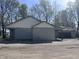 A single story house with an attached garage and carport surrounded by leafy green trees at 609 W Pearl St, Trafalgar, IN 46181