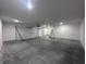A spacious garage with tall ceilings, concrete floors and bright lighting with a white door at 609 W Pearl St, Trafalgar, IN 46181