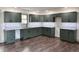 View of the modern kitchen with custom cabinets, stainless steel appliances, and hardwood floors at 609 W Pearl St, Trafalgar, IN 46181