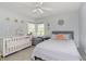 Neutral bedroom featuring a crib, chair, and bed with a ceiling fan and bright natural light at 7026 Spring Mill Rd, Indianapolis, IN 46260