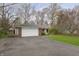 Classic brick home with attached garage and paved driveway, set amongst mature trees at 7026 Spring Mill Rd, Indianapolis, IN 46260