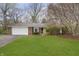 Charming single-story brick home with a well-manicured lawn and mature trees at 7026 Spring Mill Rd, Indianapolis, IN 46260
