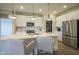 Spacious kitchen boasts white cabinets, a quartz island, and stainless steel appliances at 714 Faudree Dr, Westfield, IN 46074