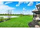 Expansive backyard featuring a covered patio with views of a tranquil pond and lush green lawn at 725 Meadowbrook Ln, Franklin, IN 46131