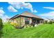 Spacious backyard featuring manicured lawn, professional landscaping and brick exterior with a covered patio at 725 Meadowbrook Ln, Franklin, IN 46131
