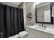 Stylish bathroom featuring modern vanity with elegant mirror, sleek toilet, and tiled shower with black shower curtain at 725 Meadowbrook Ln, Franklin, IN 46131