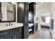 Stylish bathroom with double vanity, black cabinets, quartz countertop, and view to main bedroom at 725 Meadowbrook Ln, Franklin, IN 46131