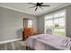 Bedroom featuring a ceiling fan, warm wood floors, and natural light from a large window overlooking the yard at 725 Meadowbrook Ln, Franklin, IN 46131