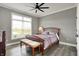 Cozy bedroom featuring a decorative ceiling fan, plush bedding, and ample natural light from a large window at 725 Meadowbrook Ln, Franklin, IN 46131