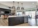 Open-concept kitchen and living room with stainless steel appliances and large central island at 725 Meadowbrook Ln, Franklin, IN 46131