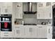 Modern kitchen with stainless appliances, white cabinets, and a stylish vent hood over the range at 725 Meadowbrook Ln, Franklin, IN 46131