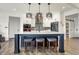 Bright kitchen featuring a large island with seating, white cabinets, and modern pendant lighting at 725 Meadowbrook Ln, Franklin, IN 46131